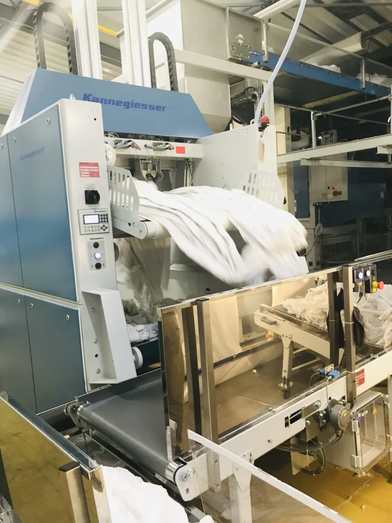 Atelier de la blanchisserie Belle Hortense : machine de finition et linge blanc