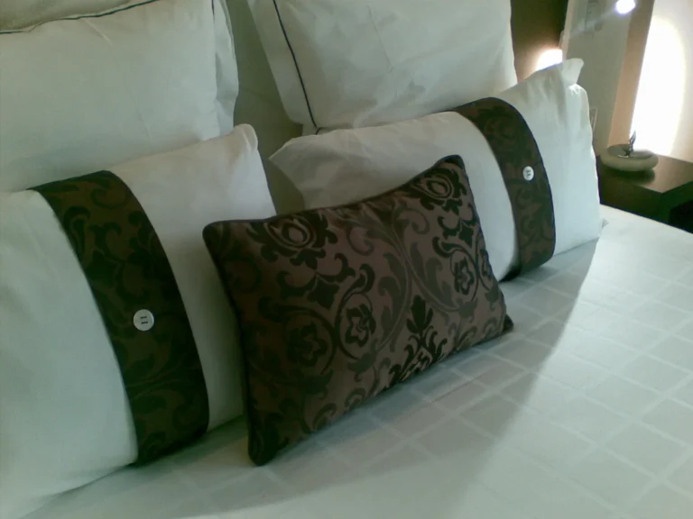 Lit aux draps blancs avec coussins décoratifs verts