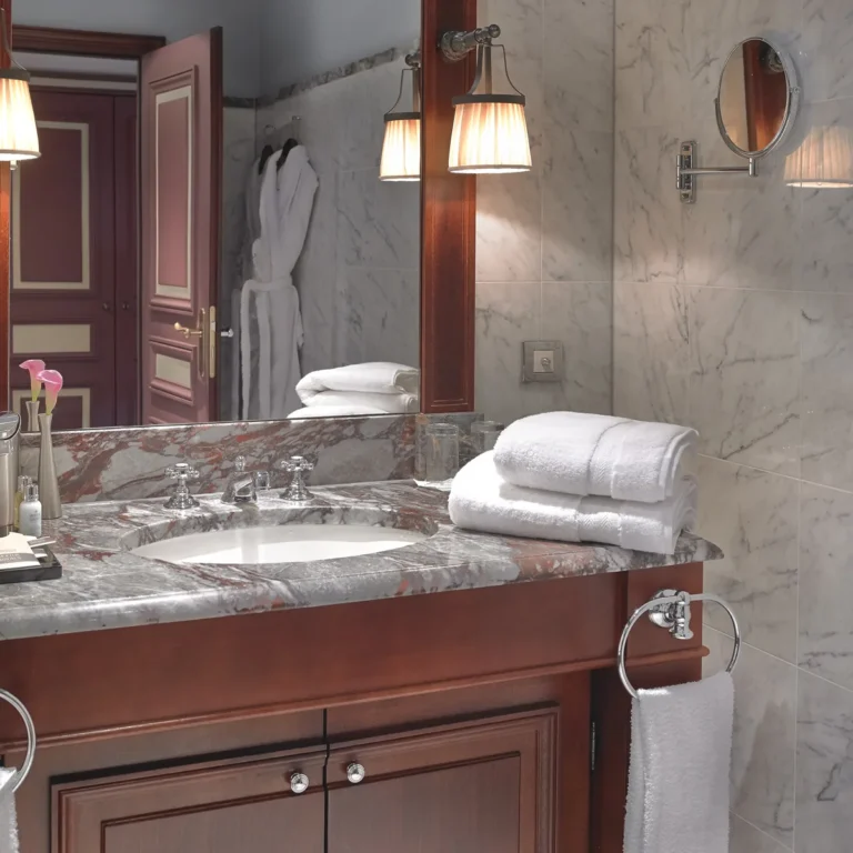 Salle de bains d'hôtel avec serviettes et peignoir blancs