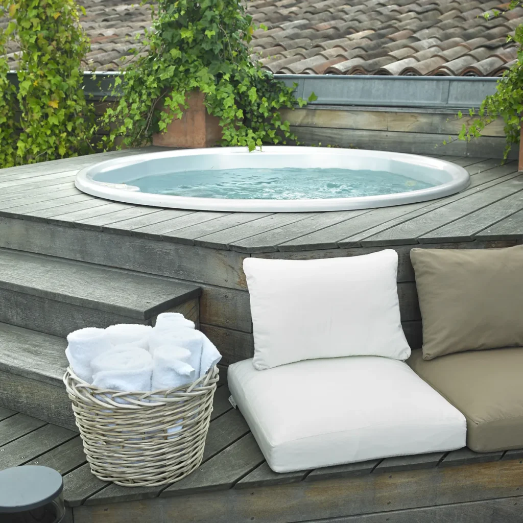 Spa extérieur avec serviettes blanches dans un panier