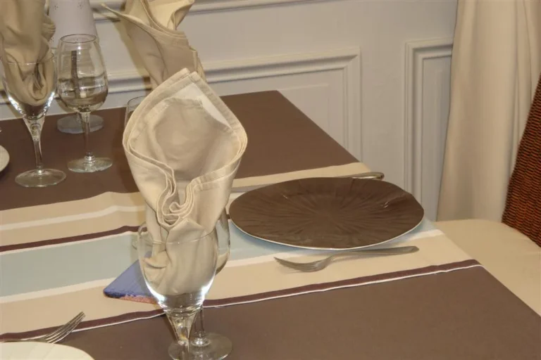 Serviette blanche pliée dans un verre, sur une table dressée