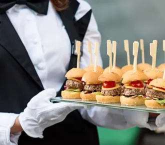 Serveur présentant un plateau de mini-burgers
